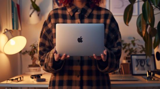 Comprar MacBook recondicionado é uma boa opção? 13 Fotografia hiper-realista de indivíduo segurando MacBook recondicionado em um espaço de trabalho moderno e minimalista.
